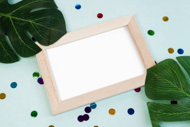 İçinde konfeti olan mavi bir arka planda mesaj ya da reklam için boş bir yer olan fotoğraf çerçevesi. Tropik hafta sonu partisi.