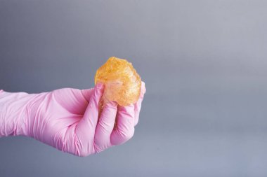 El balmumu tutuyor. Arka plandaki epilasyon yapıştırıcısı.