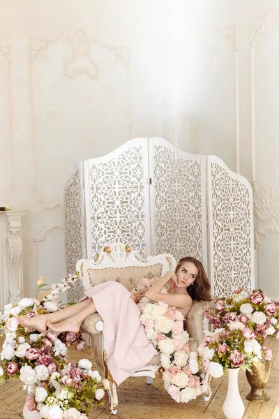 Sarışın, yüksek topuklu, çıplak omuzlu, stüdyo içi koltuklarla farklı renklerde poz veren beyaz kadın..