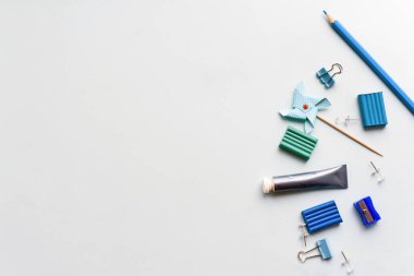Mavi arka planda kırtasiye malzemesi. Makas, kalem ve plastik, yaratıcılık için malzemeler. Boşluğu kopyala.