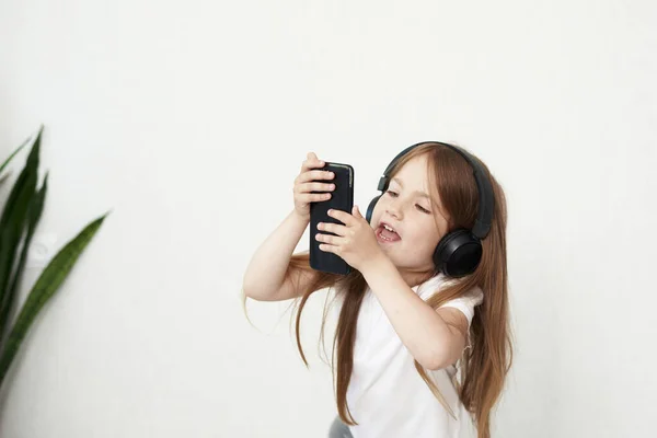 Niña Está Jugando Teléfono Fondo Niña Con Auriculares Chica Está — Foto de Stock