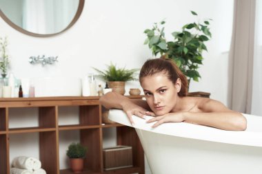 Vitiligo 'su olan güzel bir kadın banyoda kameraya gülümsüyor. Kapatın. İçerik güzel genç bayan banyo yaparken dinleniyor..