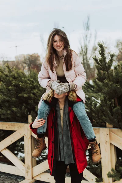 여성이 크리스마스 트리를 배경으로 남자의 어깨에 남자의 즐겁게 놉니다 연인들의 — 스톡 사진