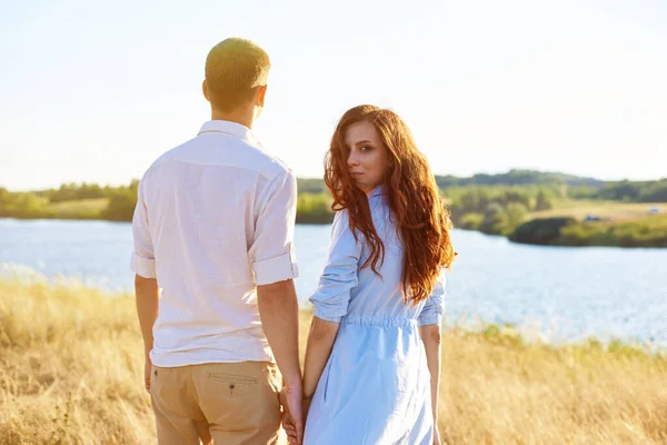 Begreppet kärlek, goda relationer, förståelse och harmoni. Härligt ungt par går i naturen och håller varandra i handen — Stockfoto