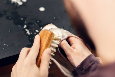 Yıkanma kabında sabunlu suyla spor ayakkabıları. Kirli ayakkabıları yıkamak, atölyede ayakkabıları temizlemek.