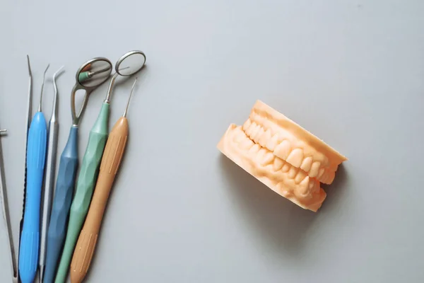 Impressione della mandibola dei pazienti e degli strumenti dentali su sfondo blu. Concetto di clinica dentale. Il concetto di correzione del morso — Foto Stock