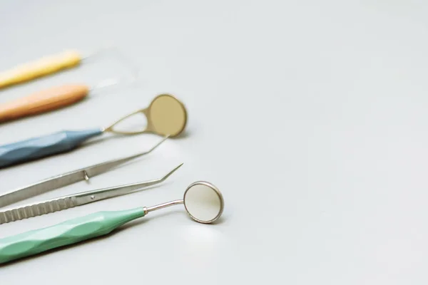 Ferramentas de dentista em um fundo cinza. Instrumentos modernos para tratamento dentário. Espaço de cópia — Fotografia de Stock