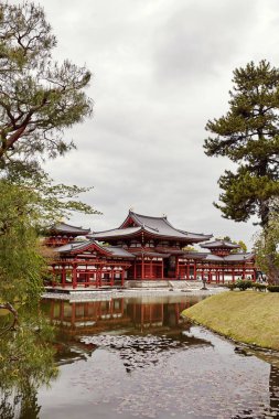 Byodoin Tapınağı bir ağaç ve Kyoto, Japonya Uji kasaba gölette arkasında.  