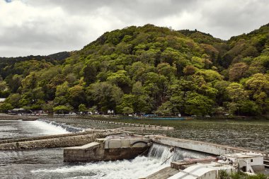 Hozu Nehri Barajı çevrili yemyeşil yeşil orman Arashiyama, Japonya