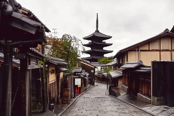Traditional Japanese architecture of buildings on a street in Kyoto, Japan with Yasaka Pagoda in the distance