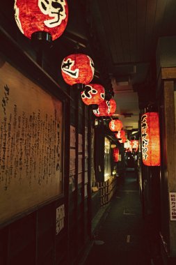 Osaka, Japonya'da geceleri karanlık bir sokağı aydınlatan fenerler