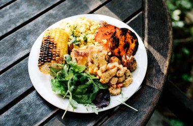 Stockholm, İsveç'te bir restoranda bir masada vegan ve vejetaryen büfe gıdalar tam bir tabak