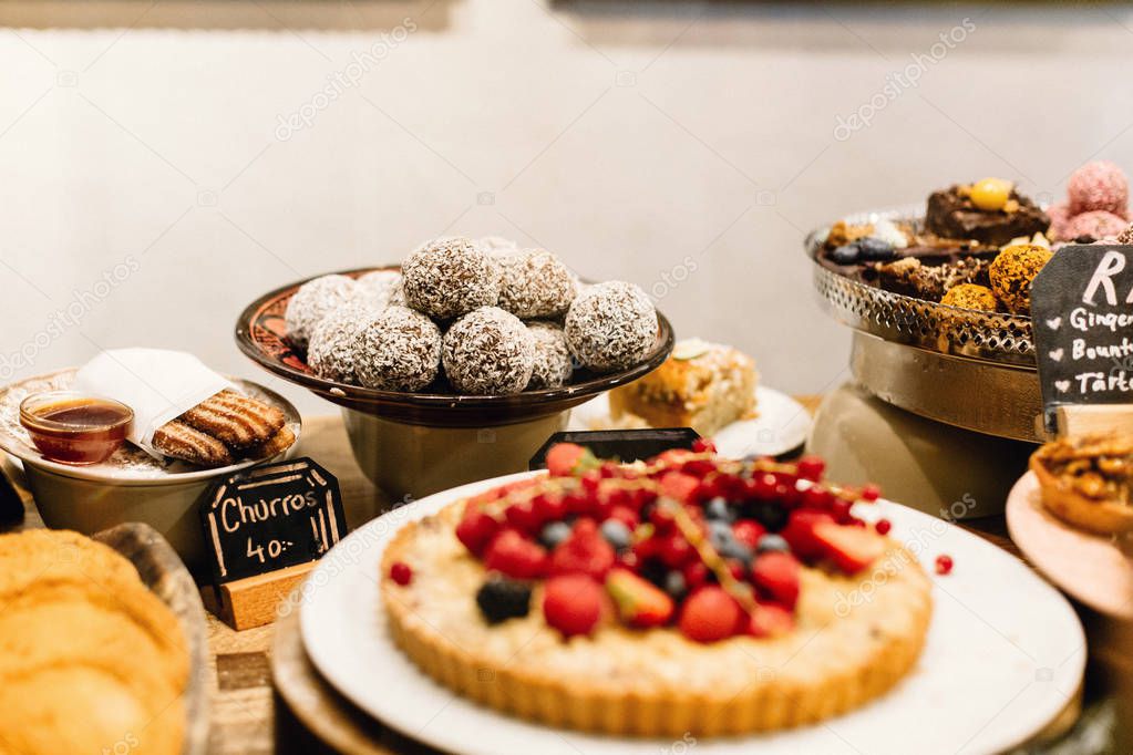 A display of vegan and vegetarian desserts and pastries on a table at a restaurant in Stockholm, Sweden
