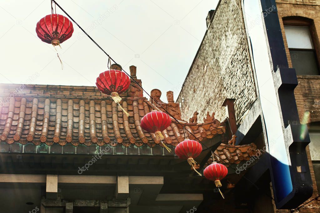 Colorful Chinatown scenery with traditional Chinese decor, architecture and paper lanterns hanging between buildings in San Francisco, California
