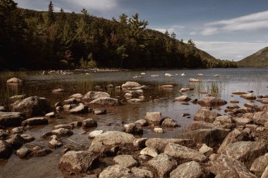 Jordan Pond, Maine 'deki Mount Desert Island' daki Acadia Ulusal Parkı 'nın arka planında baloncukları görüyor..  