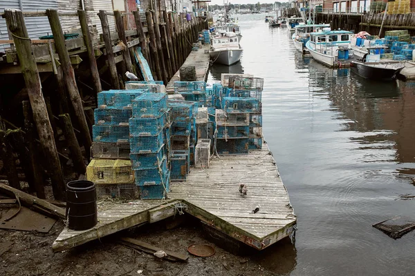 Commercial fishing wharf with stacks of lobster traps in the Old Port Harbor district of Portland, Maine.