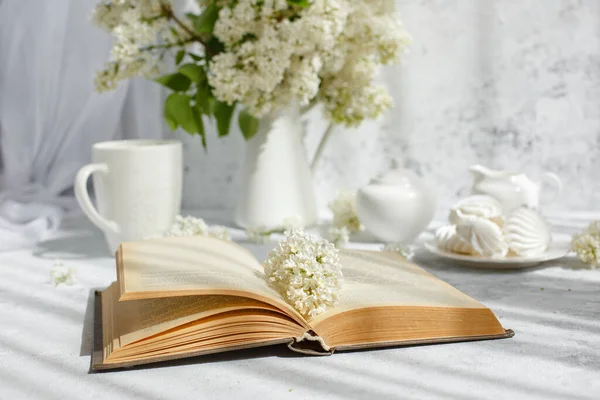 white cup of tea and books on table