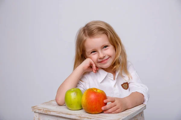 little girl with apple on a white background