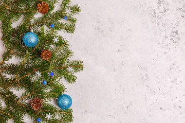 Noel arkaplanı, ağaç dalları, mavi Noel oyuncakları konileri, çelenkler, yazı yazılacak yer