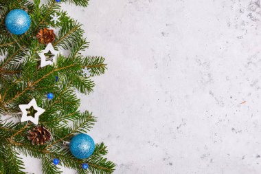 Noel arkaplanı, ağaç dalları, mavi Noel oyuncakları konileri, çelenkler, yazı yazılacak yer