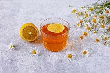 Papatyalı bir fincan çay ve bir buket papatya.