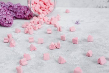 Gri arkaplanda pembe ve beyaz şekerlemeler.