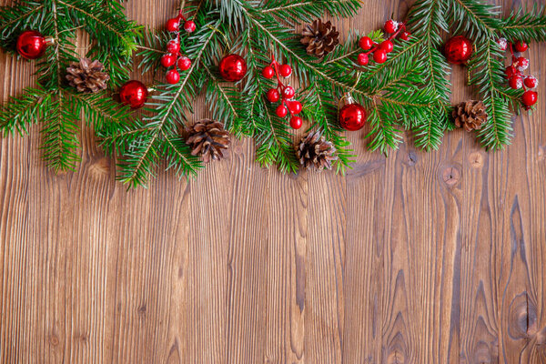 Christmas background with xmas tree and red berries on  wooden background. Merry christmas greeting card, frame, banner.