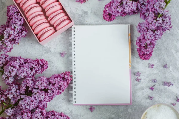 pink lilac flowers and notepad on white background. top view. flat lay, copy space.
