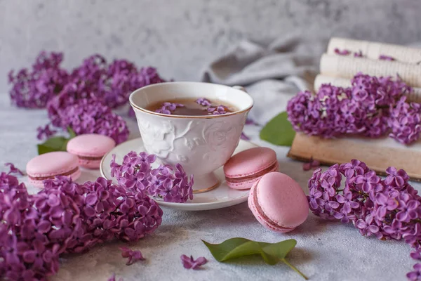 Egy Csésze Tea Lila Virágokkal Macaroons Feküdni Egy Szürke Háttér — Stock Fotó