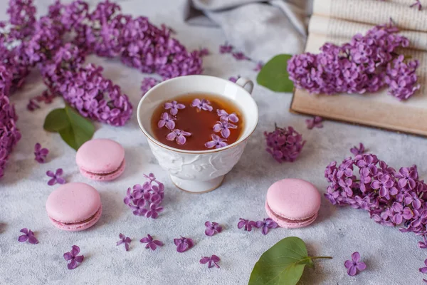 Egy Csésze Tea Lila Virágokkal Macaroons Feküdni Egy Szürke Háttér — Stock Fotó