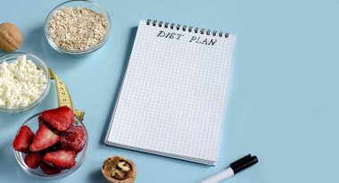 Sağlıklı yiyecek konsepti ve yazılacak not defteri. Diyet ürünleri süzme peynir, yulaf ezmesi, mavi arka planda böğürtlen. Düz yat, boşluğu kopyala