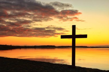 Güneşin doğuşunda nehir koyunda siyah haç. Gökyüzünde durgun suları yansıtan harika renkler..