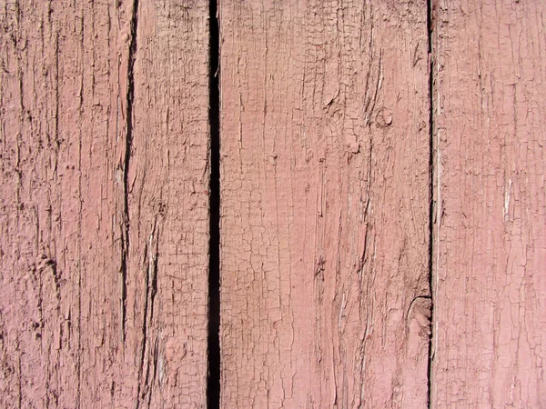 Parede de tábuas de madeira com traços de tinta rosa vermelha — Fotografia de Stock