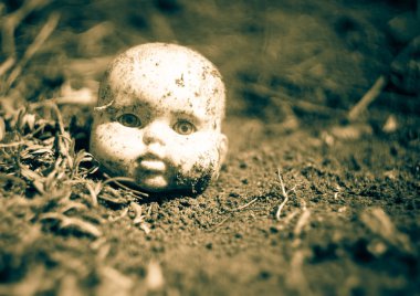 Terk edilmiş şehirde bir zemin üzerinde eski kırık korkunç bebek kafası.