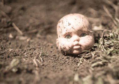 Terk edilmiş şehirde bir zemin üzerinde eski kırık korkunç bebek kafası.