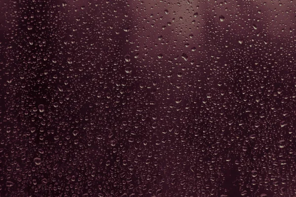 Gotas de chuva no vidro da janela, e através das janelas era uma visão noturna nebulosa . — Fotografia de Stock