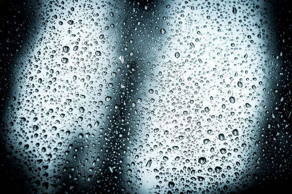 Краплі дощу на віконному склі, і через вікна був жахливий вид на ніч . — стокове фото