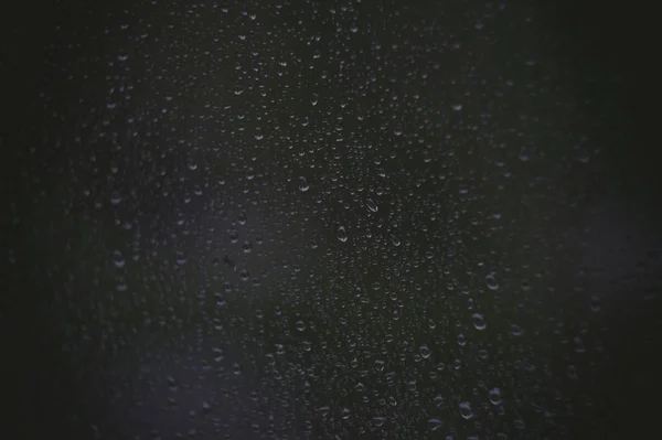 Raindrops on the window glass, and through the windows was a hazy night view. — Stock Photo, Image