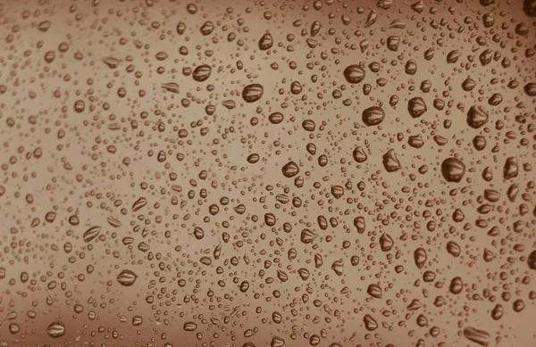 Κρυστάλλινο χρώμα νερό σταγόνες με φυσαλίδες σε μια επιφάνεια γυαλιού. — Φωτογραφία Αρχείου
