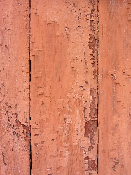 Close-up de vermelho, tinta rosa descascando superfície de madeira velha, textura de fundo. Fundo de madeira do qual a velha pintura e verniz se descascaram, textura. Tinta descasca fora prancha de madeira . — Fotografia de Stock