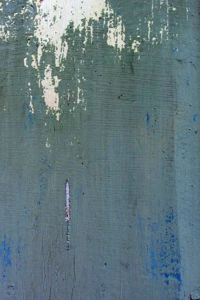 Närbild av grön och blå färg peeling gammal träyta, bakgrund konsistens. Trä bakgrund från vilken den gamla färgen och lack skalade bort, konsistens. Måla peeling av trä planka. — Stockfoto