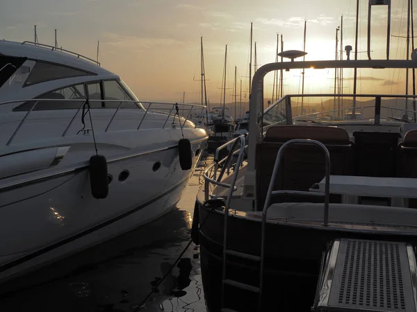 Two luxury yachts docked at the port of Saint-Tropez during a be