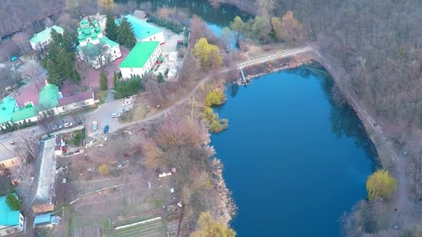 Volando sobre el monasterio cerca del río en el bosque — Vídeos de Stock