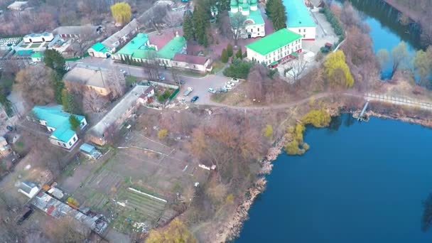 Flying over the monastery near the river in the forest — Stock Video