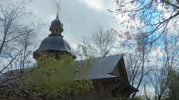 4K tidsfördröjning. Träkyrkan i den gamla ryska stilen med ett gyllene kors i parken i staden Kiev — Stockvideo