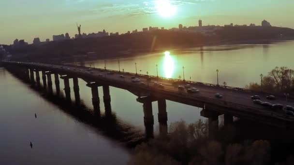 Воздушный вид на мост через широкую реку Днепр в Киеве перед закатом весной — стоковое видео