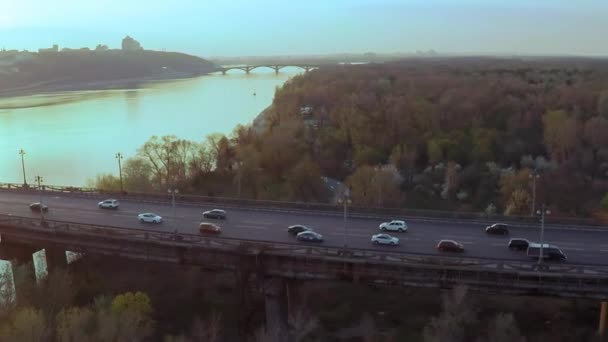 Luchtfoto van de brug over de brede Dnjepr rivier in Kiev voor zonsondergang in het voorjaar — Stockvideo
