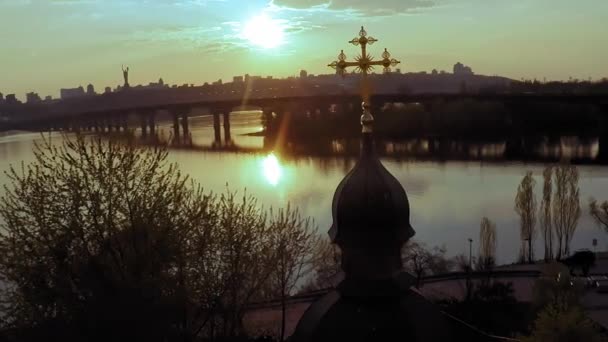 Vista aérea de una iglesia de madera con una gran cruz dorada cerca del ancho río Dniéper en Kiev — Vídeos de Stock