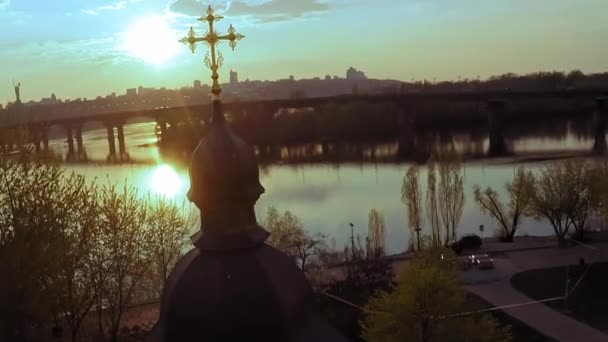 Aerial view of a wooden church with a large golden cross near the wide river Dnieper in Kiev — Stock Video
