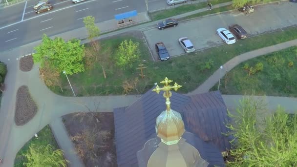 Εναέρια θέα μιας ξύλινης εκκλησίας με ένα μεγάλο χρυσό σταυρό κοντά στον Πλατύ κνείπερο ποταμού στο Κίεβο — Αρχείο Βίντεο